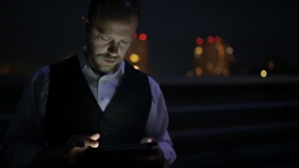 Homem de terno usando tablet digital à noite — Vídeo de Stock