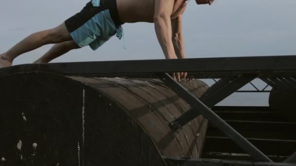 Man exercising with push ups on metal structures at the river — Stock Video