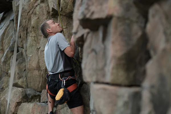 Masculino alpinista apega-se a um penhasco — Fotografia de Stock