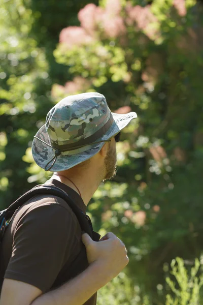 Männliche Touristen mit Hut, die allein im Wald spazieren gehen. abgeschnittener Schuss. — Stockfoto