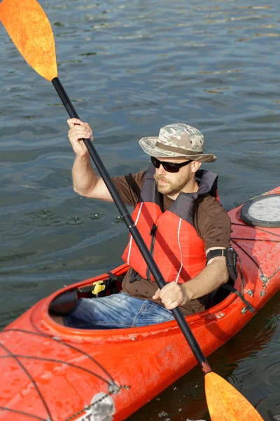 Man boating in red canoe in river at summer day — Stock Photo, Image