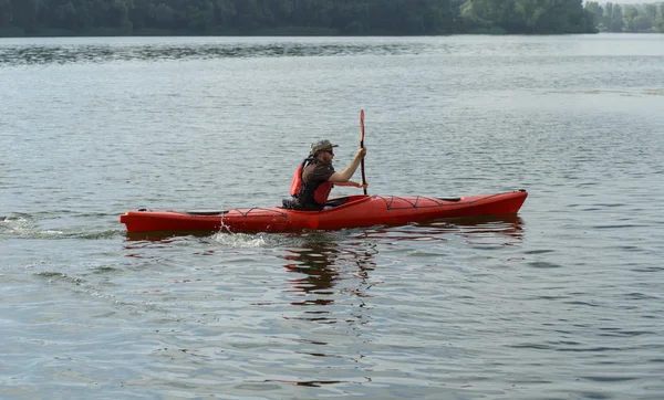 Man boating in red canoe in river at summer day — Stock Photo, Image