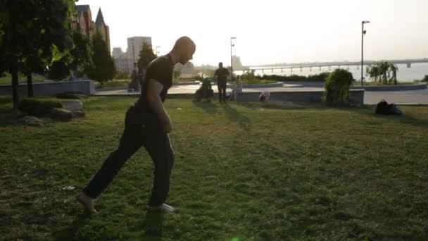 Людина-фрірун біжить і стрибає в місто на заході сонця — стокове відео