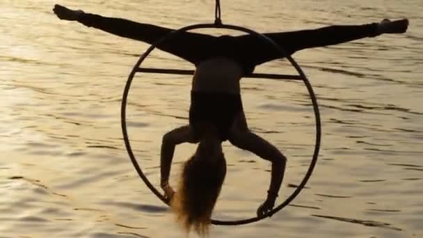 Silhouet van de vrouw doet prachtige acrobatische element boven het water — Stockvideo