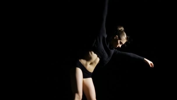 Flexible junge Frau tanzt zeitgenössisch auf schwarzem Hintergrund — Stockvideo