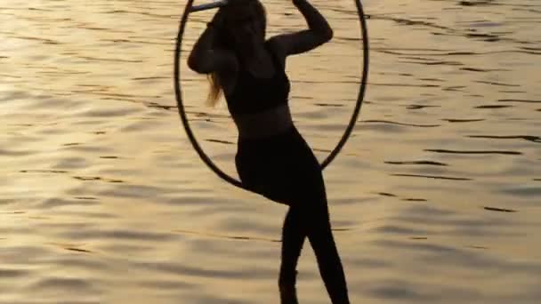Silueta mujer haciendo espectáculo de gimnasia aérea por encima del agua — Vídeos de Stock