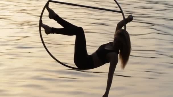 Silhouette of air gymnastics woman hanging above the water — Stock Video