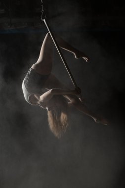 Kadın acrobat jimnastik öğe serpilir un ile hava çember üzerinde yapıyor