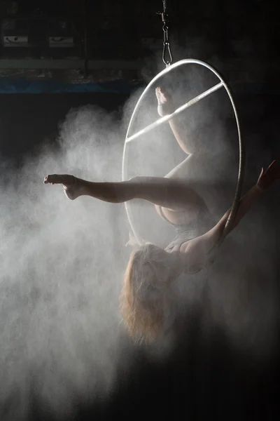 Acrobata fêmea fazendo elemento ginástica em aro aéreo com farinha polvilhada — Fotografia de Stock