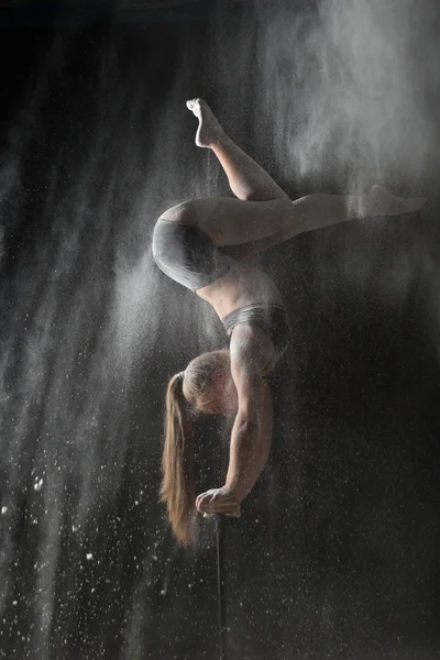 Woman gymnast handstand on equilibr while sprinkled flour — Stock Photo, Image