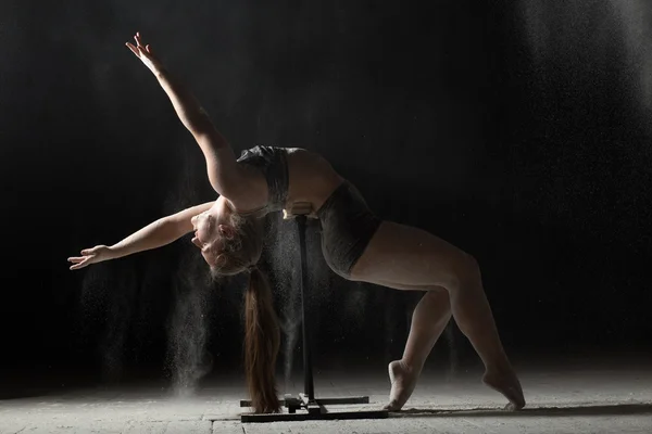 Mulher fazendo ginástica elemento em stand enquanto a farinha polvilhada — Fotografia de Stock