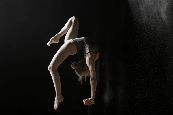 Kadın jimnastikçi hareketten equilibr siyah arka plan üzerinde — Stok fotoğraf