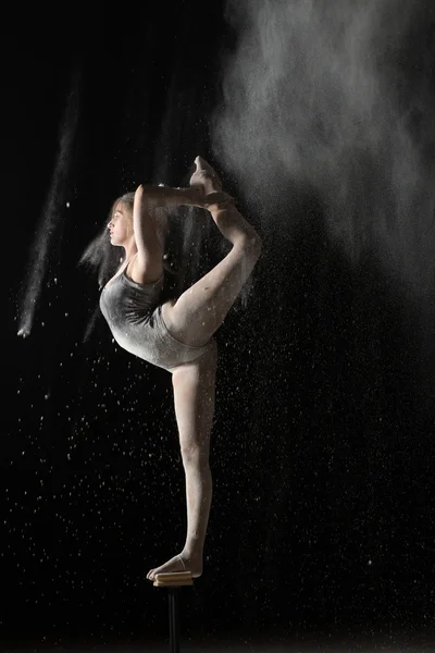 Gimnasia mujer flexible de pie en soporte de equilibrio, mientras que la harina espolvoreada — Foto de Stock