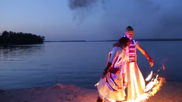 Fireshow výkon s hořící pochodní poblíž řeky ve večerních hodinách — Stock video