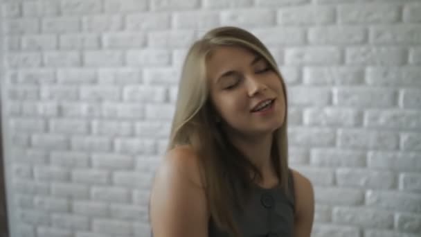 Sevimli samimi kurtarılmış kadın beyaz tuğla duvar arka plan üzerinde poz — Stok video