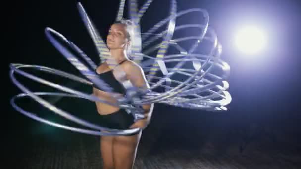 Sanat jimnastik. Kadın olay yerinde birçok hula hoop döndürmek. — Stok video