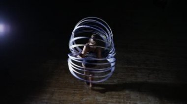Profesyonel kadın akrobatik oyuncusu döndürmek hula hoop sahnede