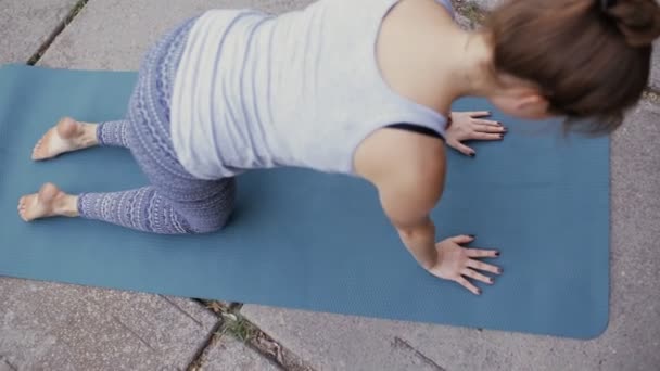 Kvinna som utövar yoga på trottoaren — Stockvideo