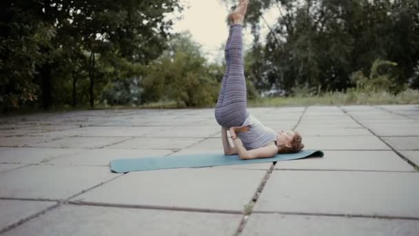 Женщина практикует йогу на тротуаре — стоковое видео
