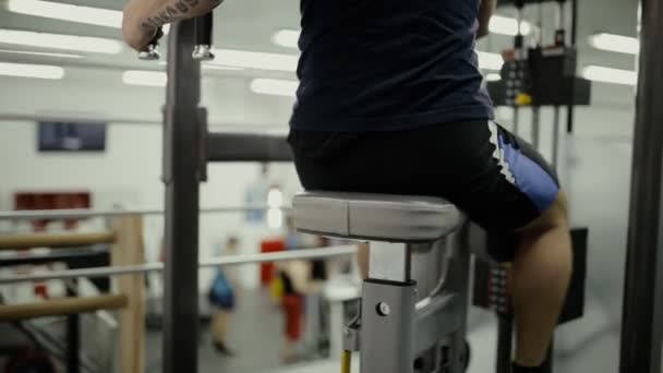 Człowiek robi ćwiczenia na sprzęt do ćwiczeń w siłowni — Wideo stockowe