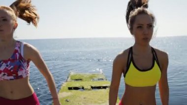 Sportif kız deniz iskelede atlama. Egzersiz eğitim.