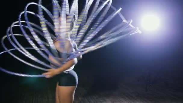Umělecké gymnastiky. Žena otočit mnoho hula hoop na scéně. — Stock video