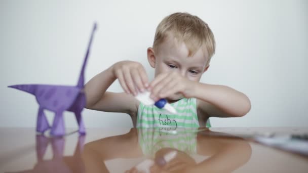 Vorschulvorbereitung. Kleiner Junge klebt Papier. — Stockvideo