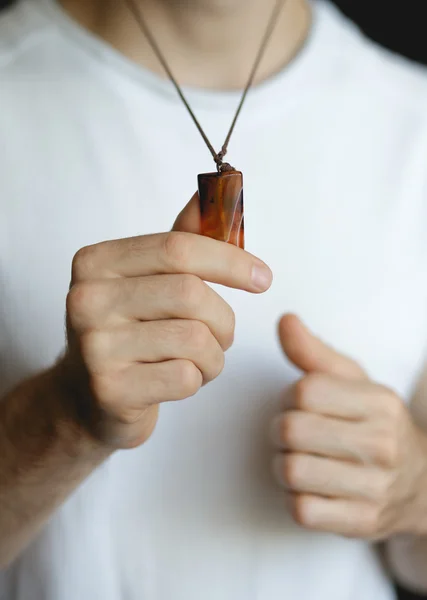 Homem segurando sardonyx pendente close-up — Fotografia de Stock