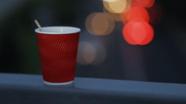 Buenas noches con una taza de té en el fondo luces de la noche — Vídeo de stock