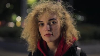 Kıvırcık kadın portresi kameraya bakar