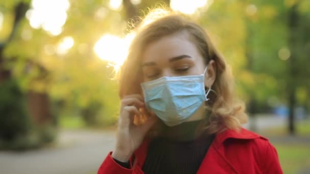 Woman take off surgical mask in a park — Stock Video