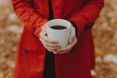 Sonbahar günü bir kadının elinde kahve fincanı