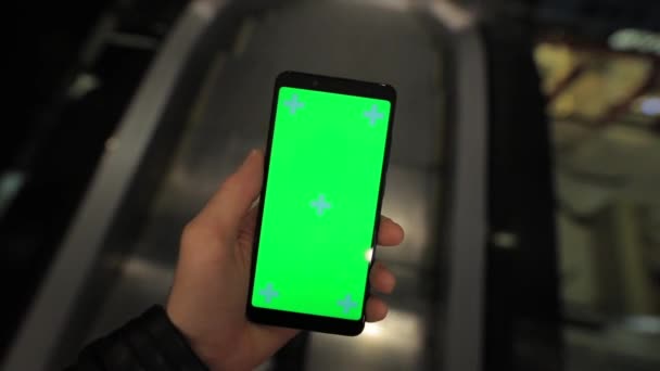 POV, manlig hand med hjälp av smartphone med grön skärm i rulltrappan till köpcentret — Stockvideo