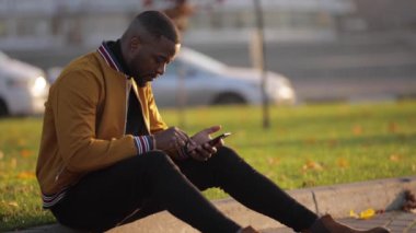 Afrika kökenli Amerikalı bir adam sınırda telefon kullanıyor.