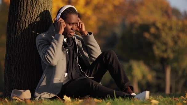 Afrikaanse man luistert naar muziek in hoofdtelefoon — Stockvideo