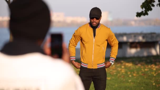 African friends photographing a male fashion portrait — Stock Video