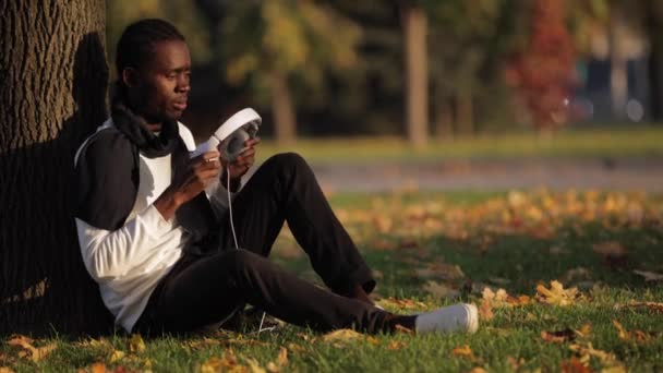 African man listening to music in headphones — Stock Video