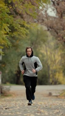 Parkta koşan adam, dikey video.