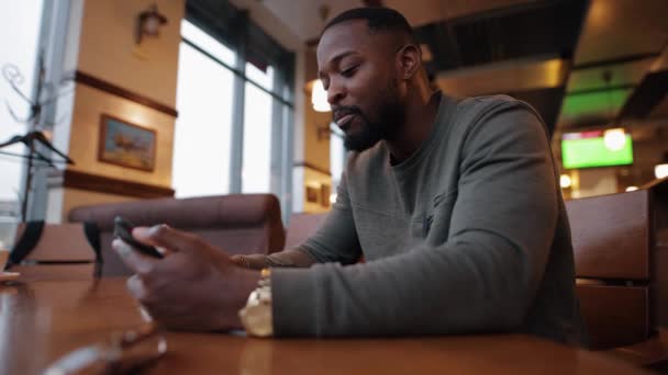 Afro-americano homem online conversando em um café — Vídeo de Stock