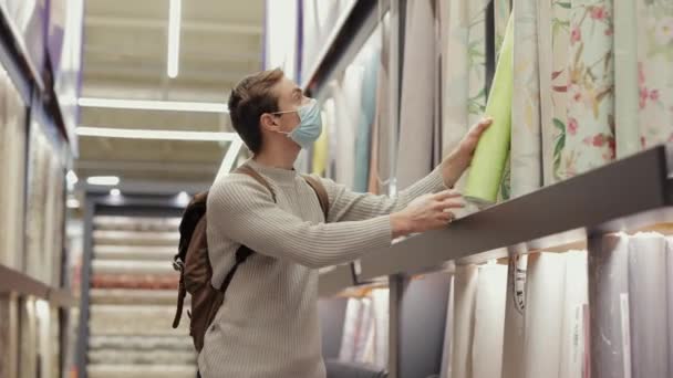 Homme acheteur choisit un papier peint dans le magasin — Video