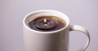 Kahve fincanına süt damlası düşüyor.