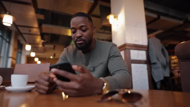 Αφροαμερικανός σε απευθείας σύνδεση συνομιλία σε ένα καφέ — Αρχείο Βίντεο