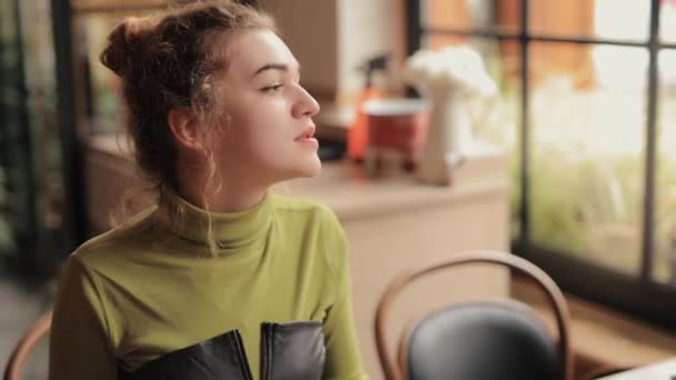 Młoda kobieta pije herbatę w kawiarni — Wideo stockowe