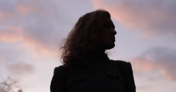 Silhouette de femme tourner son visage sur fond de ciel nuageux — Video
