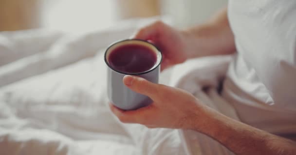 男人早上坐在床上喝茶 — 图库视频影像
