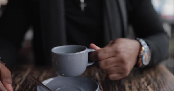 Hombre afroamericano bebiendo té sentado en un café, cámara lenta — Vídeos de Stock