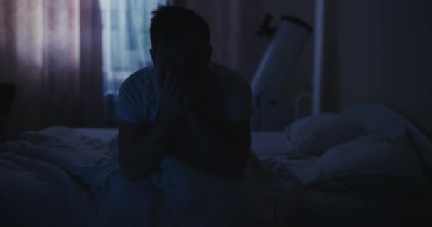 Yataktaki depresyondaki adam uykusuzluk belirtilerinden muzdarip. — Stok video