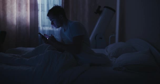 Mann benutzt Handy im Bett, Blaulicht — Stockvideo