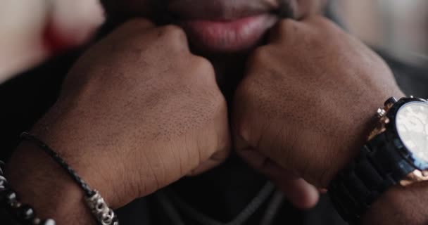 Brutal confident African man sitting at the table leaning head on hands — Stock Video