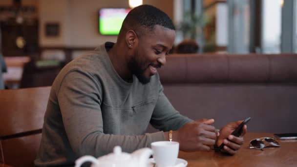 Afroamerikaner chatten online in einem Café mit Luftkuss — Stockvideo